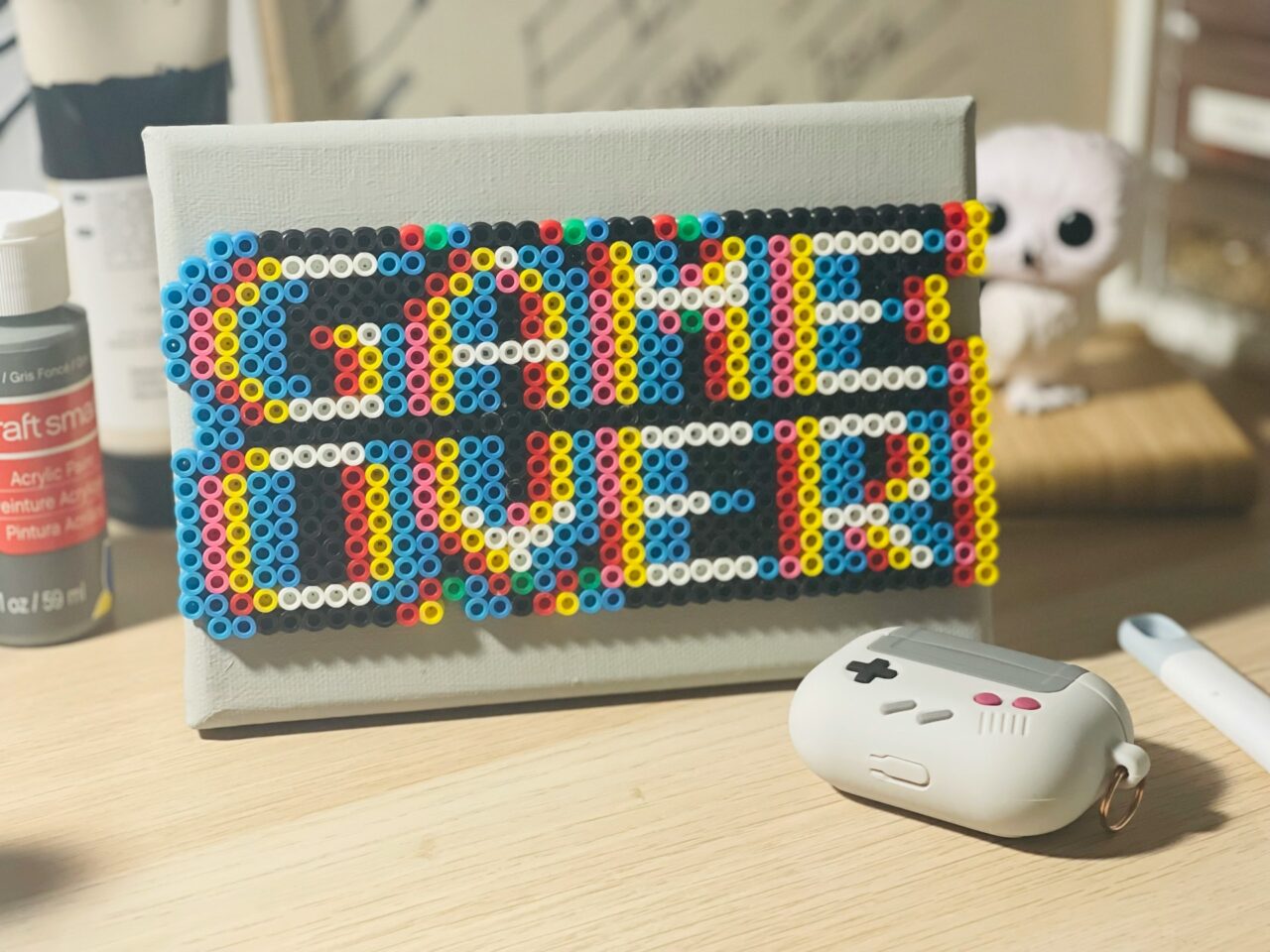 Gamification problems eLearning motivation: colorful bead GAME OVER sign next to a retro game controller case