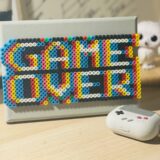 Gamification problems eLearning motivation: colorful bead GAME OVER sign next to a retro game controller case